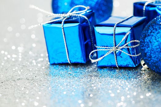 Decorative Christmas balls and gifts on silver bokeh background