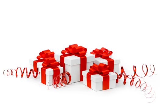 White gift boxes with red ribbon bows isolated on white background close-up