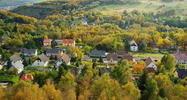 Autumn colorful landscape with forests, hills, sun and sky