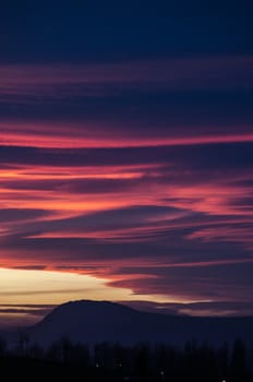 Orange and purple fluffy clouds at sunset over Etxauri s peak at Navarra, Spain