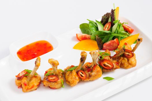 fried chilli chicken wings with vegetable salad and hot sauce