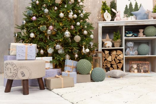 Gift boxes wrapped around the Christmas tree on the background. Cozy house is decorated to celebrate the New year.