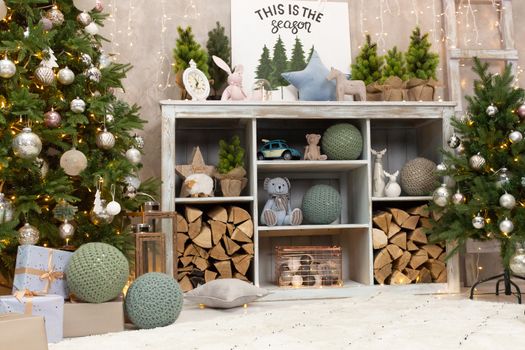 Gift boxes wrapped around the Christmas tree on the background. Cozy house is decorated to celebrate the New year.