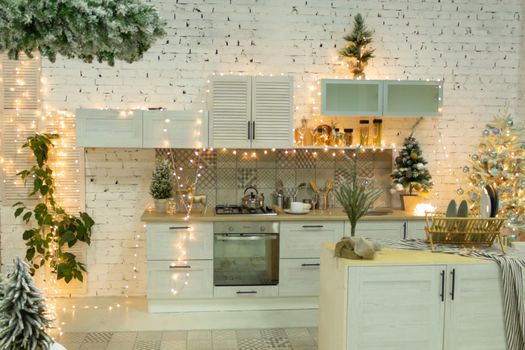Beautiful kitchen in white decorated to celebrate Christmas and New year. Set the table.