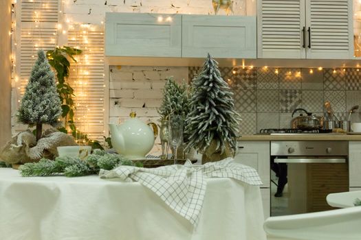 Beautiful kitchen in white decorated to celebrate Christmas and New year. Set the table.