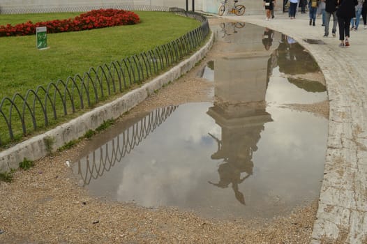 A reflection in a puddle after the rain Statue in the Vittoriano monument of Vittorio Emanuele II in Rome, Italy on October 07, 2018.