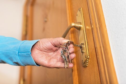 Senior man Locking up door with key in hand