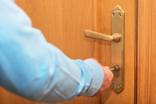Senior man Locking up door with key in hand