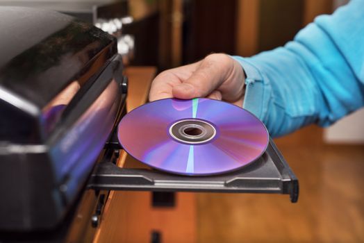 Hand holding DVD inserting to video player