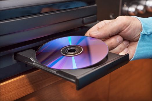 Hand holding DVD inserting to video player