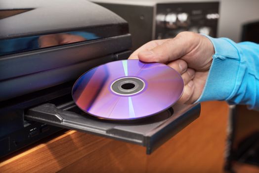 Hand holding DVD inserting to video player