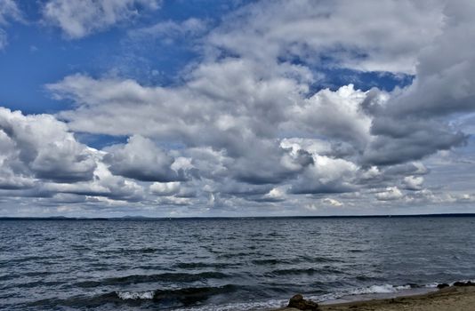 day lake in gray-white cloudy weather, South Ural, Uvildy, in the distance are seen the Ural mountains