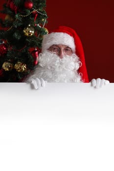 Santa Claus holding white paper billboard with copy space for text