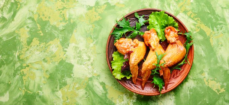 Smoked chicken wings and leaf salad. Fast food.American Cuisine