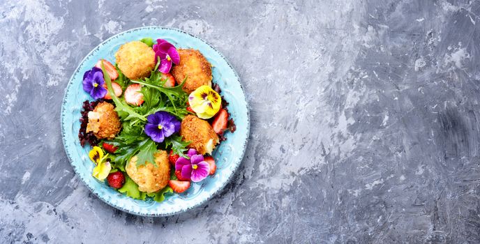 Vitamin summer salad with strawberries, grilled cheese, arugula and flowers.Healthy food