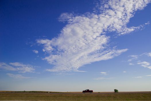 Car is running on the freeway of the country side in America. America is a continent where American mainly live. 