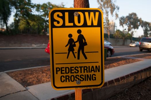 Sign says SLOW PEDESTRIAN CROSSING on the street of Los Angels, America. Street signs means the traffic rule, advertising, or many things.