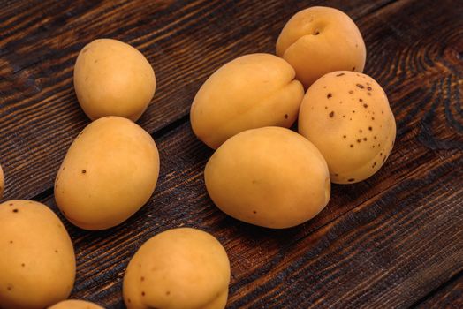 ripe apricots on dark wooden table background