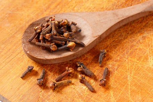 Dried cloves on wooden spoon