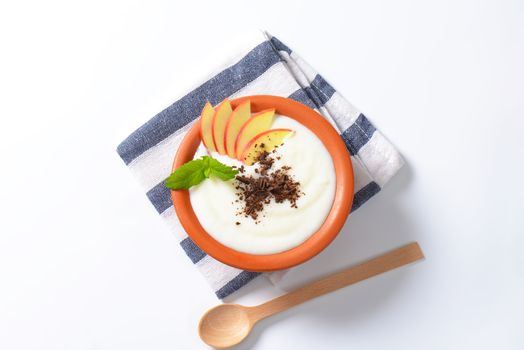 Bowl of milk pudding with apple slices and grated chocolate