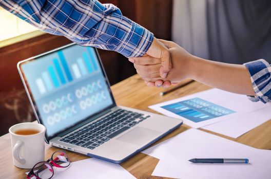 businesspeople shaking hands to seal a deal with his partner  in office. Teamwork , hipster tone