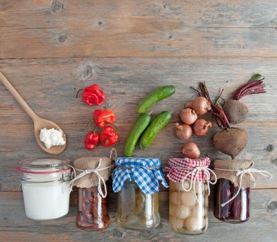 Naturally fermented foods in jars including kefir, gherkins and peppers and onions