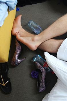 Male legs, female shoes and empty mineral bottles.