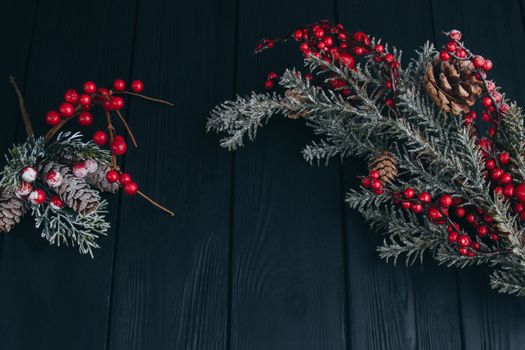 Christmas composition. Fir branches needles and berries of viburnum on a black background. New Year's composition