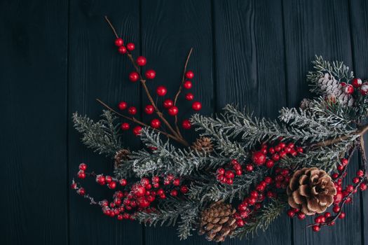 Christmas composition. Fir branches needles and berries of viburnum on a black background. New Year's composition