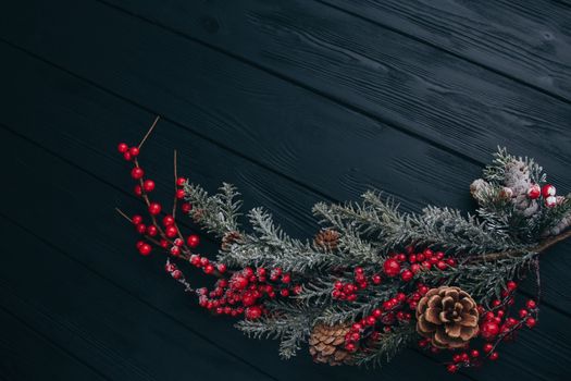 Christmas composition. Fir branches needles and berries of viburnum on a black background. New Year's composition