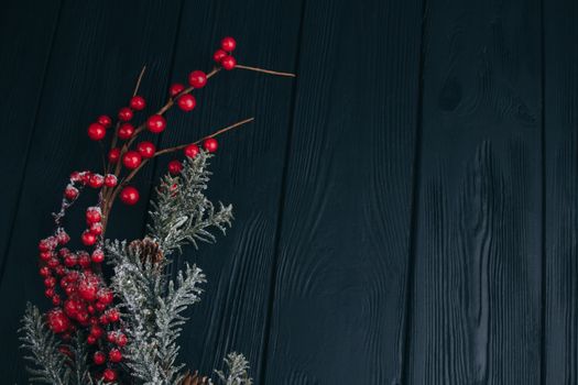 Christmas composition. Fir branches needles and berries of viburnum on a black background. New Year's composition