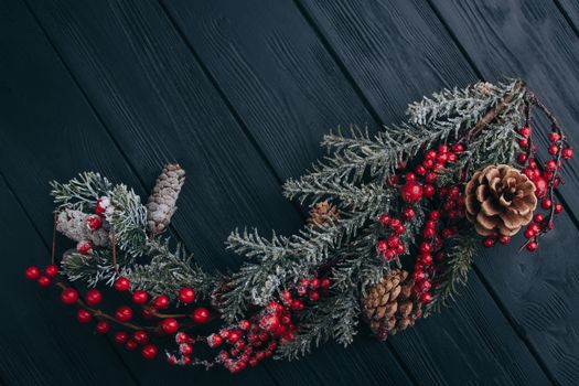 Christmas composition. Fir branches needles and berries of viburnum on a black background. New Year's composition