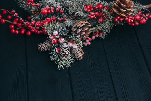 Christmas composition. Fir branches needles and berries of viburnum on a black background. New Year's composition