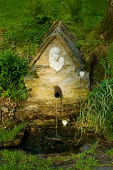 A old forest fountain with drinking water.