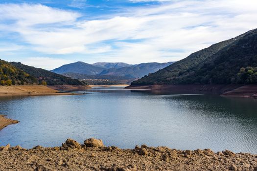 Ladonas artificial lake in Arcadia, Greece against a blue sky with clouds, and mountains as background