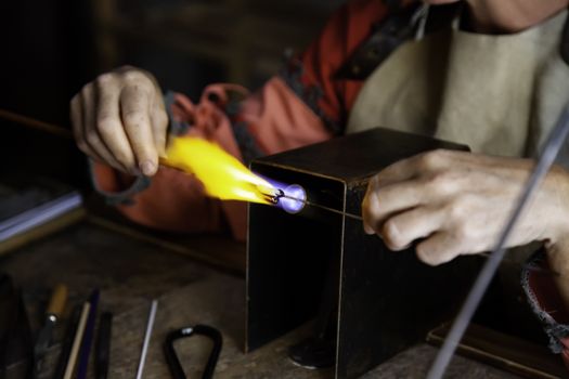 Blowing glass in a traditional way, handicraft detail with glass