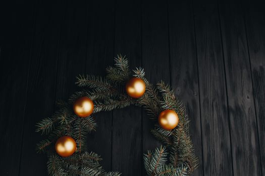 Christmas or New Year toy decorations golden ball and fur tree branch rustic on wooden background, top view, copy space