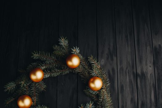 Christmas or New Year toy decorations golden ball and fur tree branch rustic on wooden background, top view, copy space