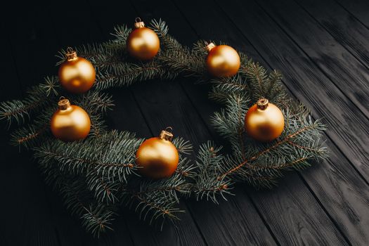 Christmas or New Year toy decorations golden ball and fur tree branch rustic on wooden background, top view, copy space