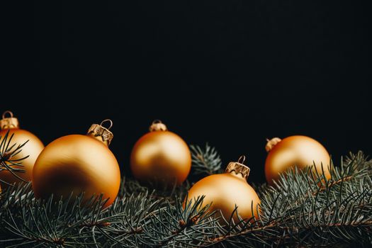 Christmas or New Year toy decorations golden ball and fur tree branch rustic on wooden background, top view, copy space