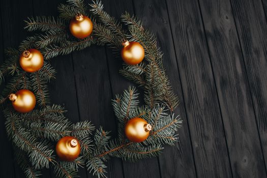 Christmas or New Year toy decorations golden ball and fur tree branch rustic on wooden background, top view, copy space