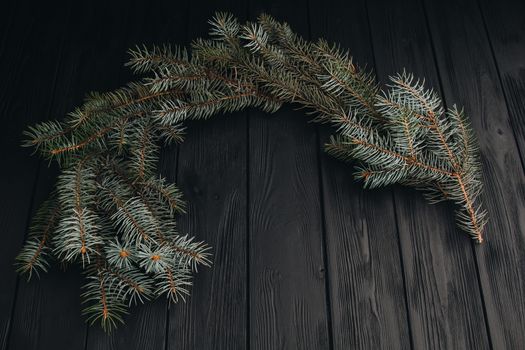 Christmas or New Year toy decorations golden ball and fur tree branch rustic on wooden background, top view, copy space