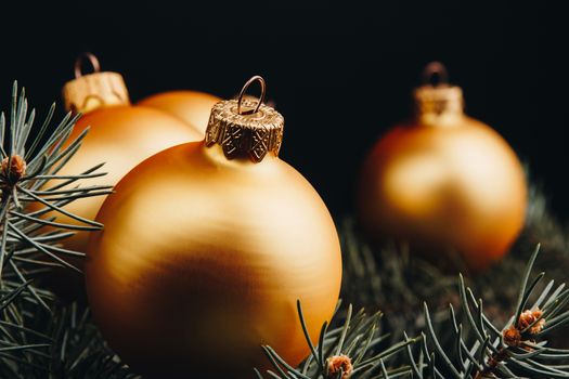 Christmas or New Year toy decorations golden ball and fur tree branch rustic on wooden background, top view, copy space