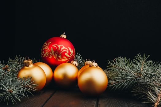 Christmas or New Year toy decorations golden ball and fur tree branch rustic on wooden background, top view, copy space