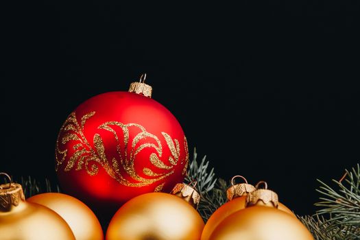 Christmas or New Year toy decorations golden ball and fur tree branch rustic on wooden background, top view, copy space