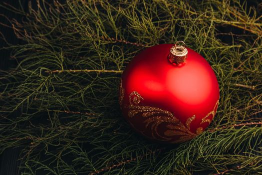 Christmas New Year decoration composition. Top view of fur-tree branches and balls frame on wooden background with place for your text.