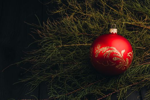 Christmas New Year decoration composition. Top view of fur-tree branches and balls frame on wooden background with place for your text.