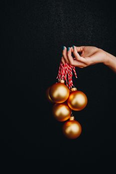 golden Christmas balls in hand isolated on black background. new year card