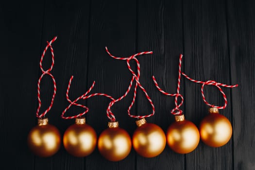 Colored christmas decorations on black wooden table. Xmas balls on wood background. Top view, copy space. new year