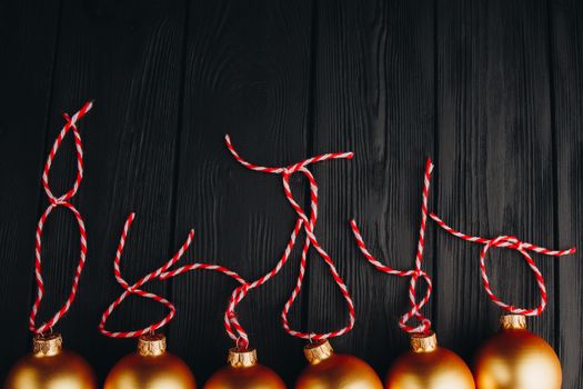 Colored christmas decorations on black wooden table. Xmas balls on wood background. Top view, copy space. new year